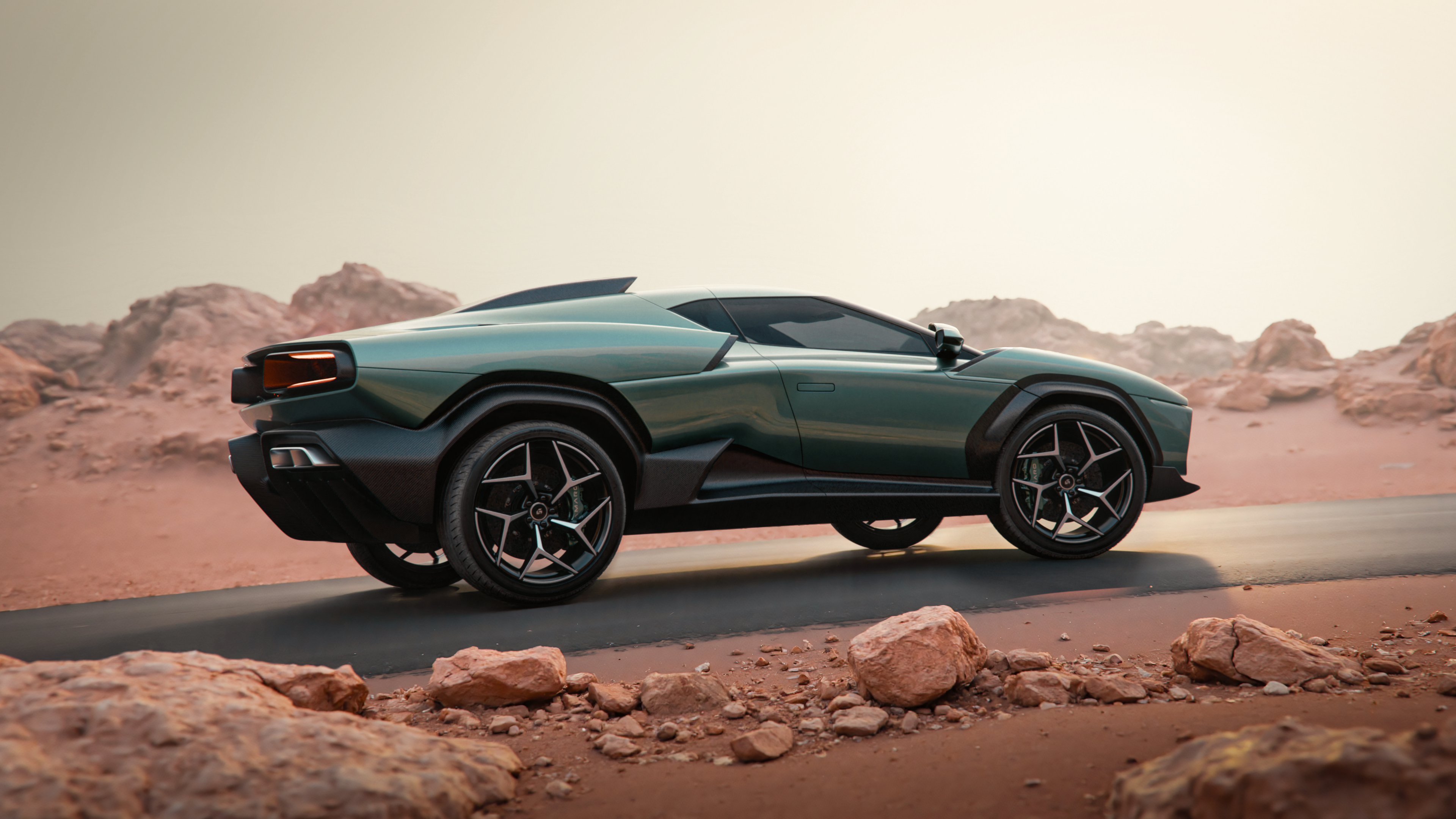 A side rear view of the green Giamaro Albor on a road in a rocky, arid landscape.
