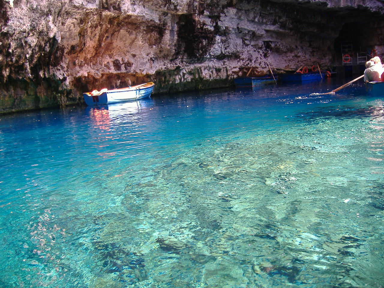 Boats on the turquoise lake inside Melissani Cave.