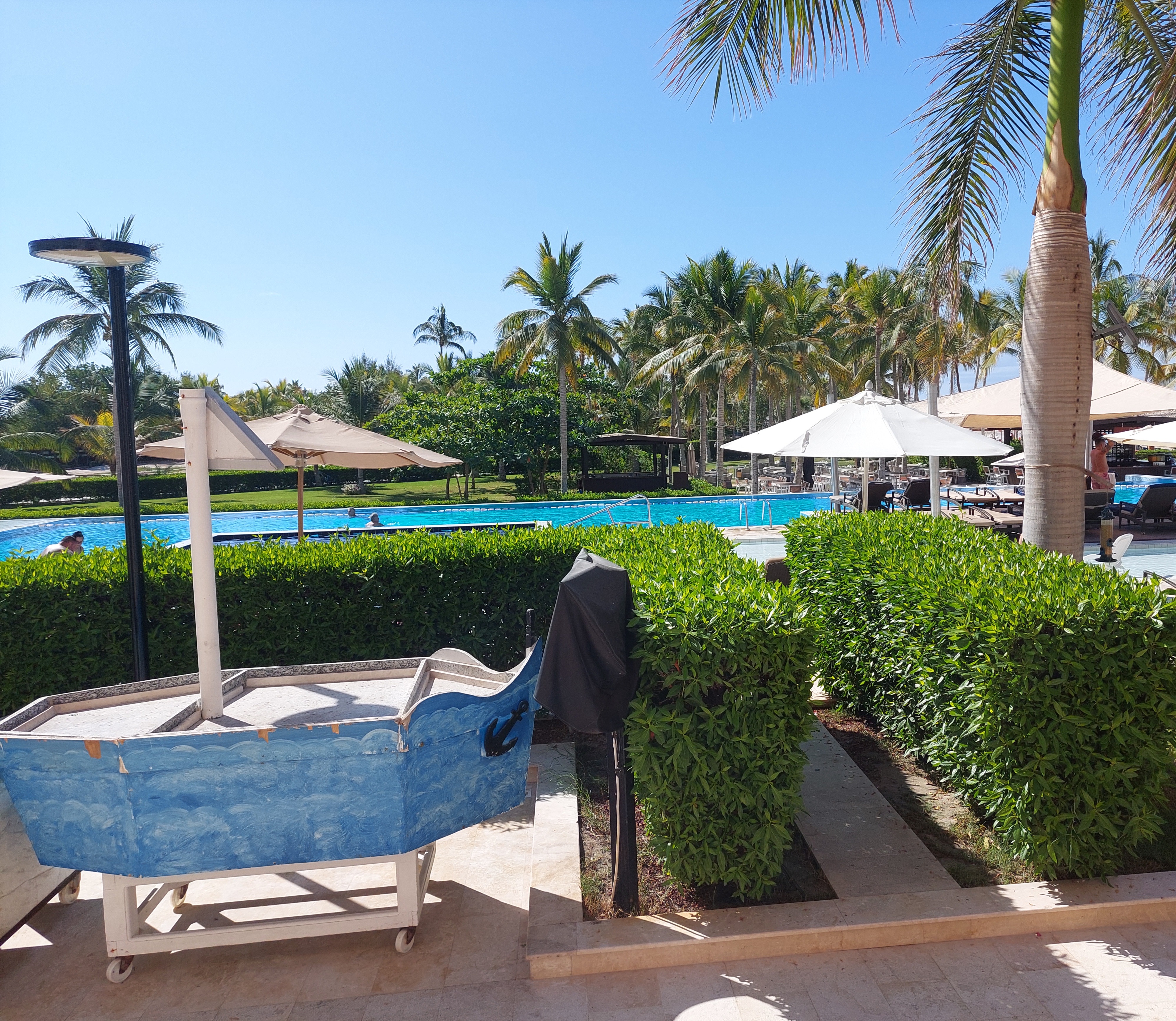 Serene swimming pool at Fanar Hotel Salalah, surrounded by palm trees.