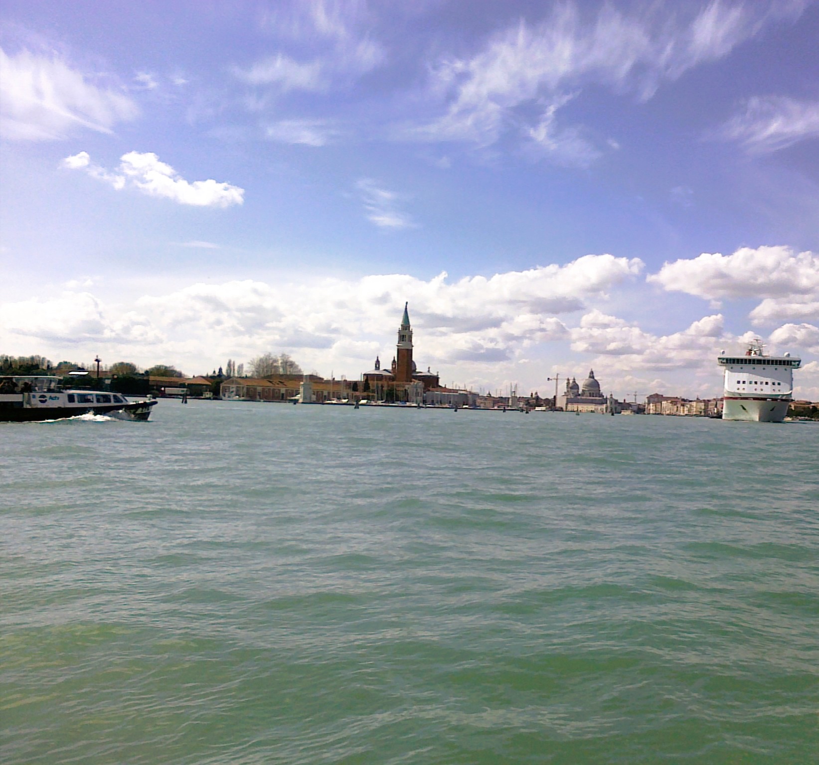A boat on the Grand Canal in Venice with the Campanile tower in the distance.