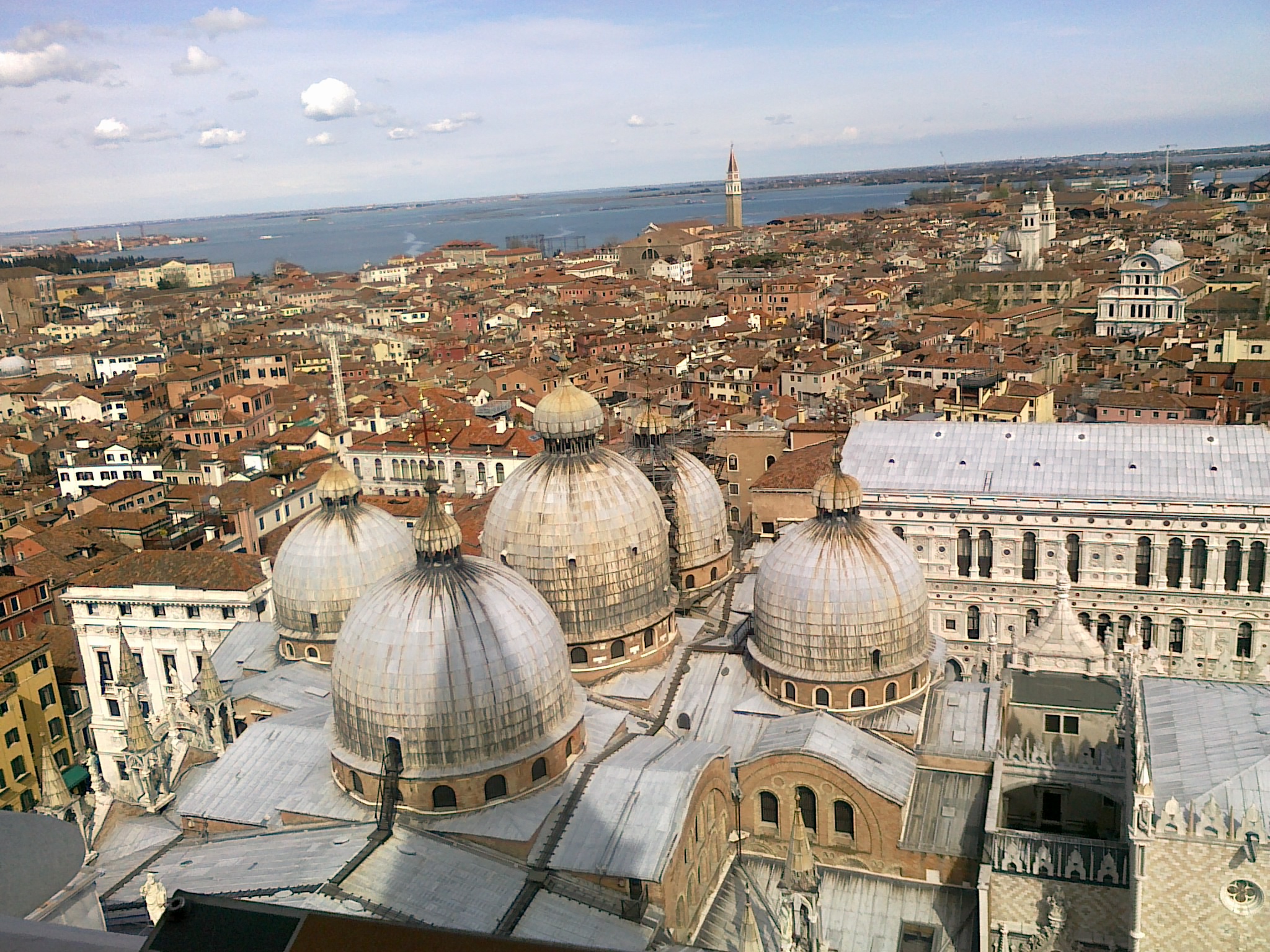 An aerial view of Venice rooftops with the domes of Santa Maria della Salute in the foreground.